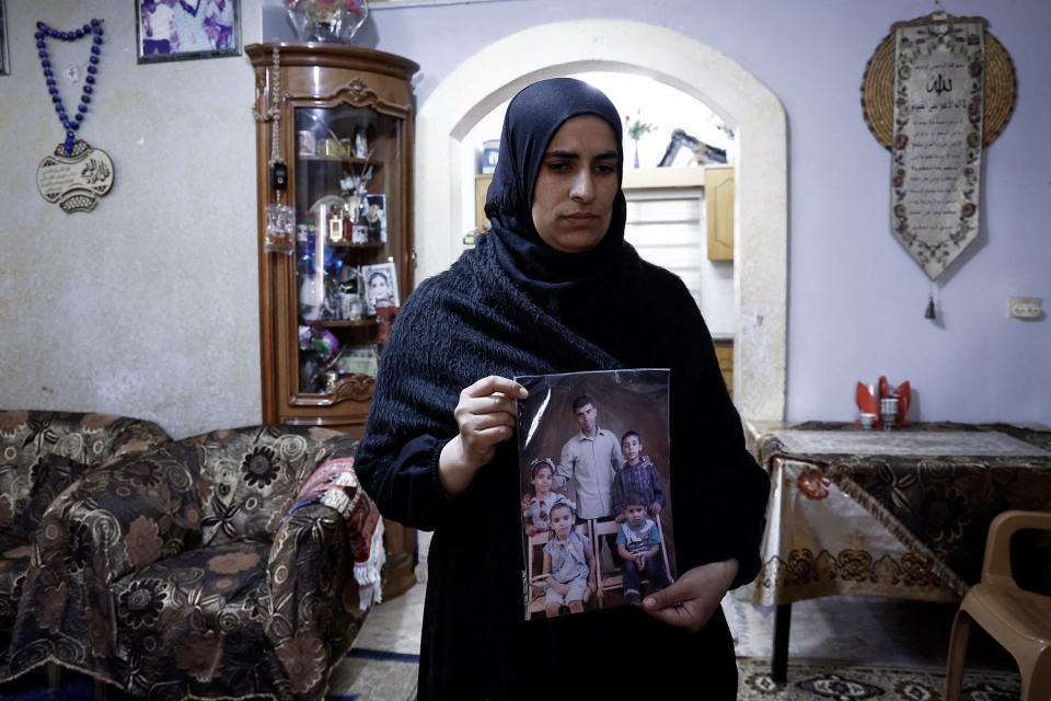 The wife of Palestinian Bilal Saleh shows a picture her late husband in the West Bank village of As-Sawiyah on Nov. 29, 2023. (Kenzo Tribouillard  / AFP via Getty Images)