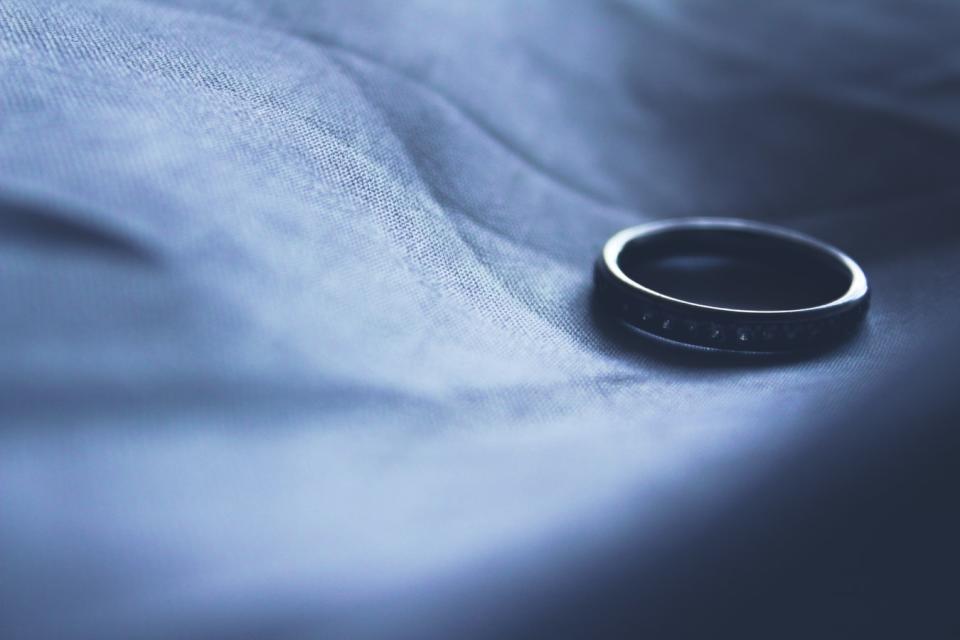 A wedding ring in the palm of a person's hand.