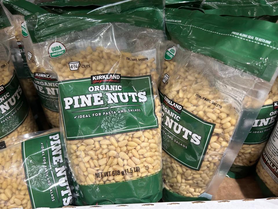 Bags of Kirkland Signature pine nuts on the shelves at Costco.