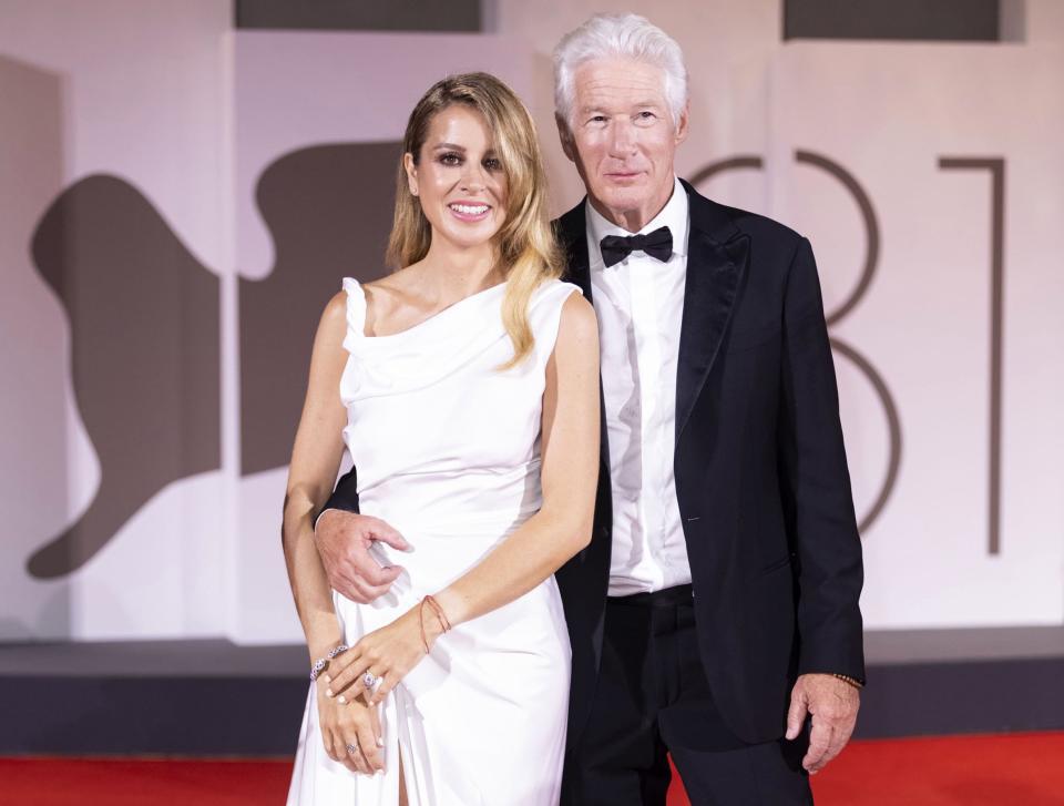 Richard Gere stands with his arm around wife Alejandra Silva on the red carpet.