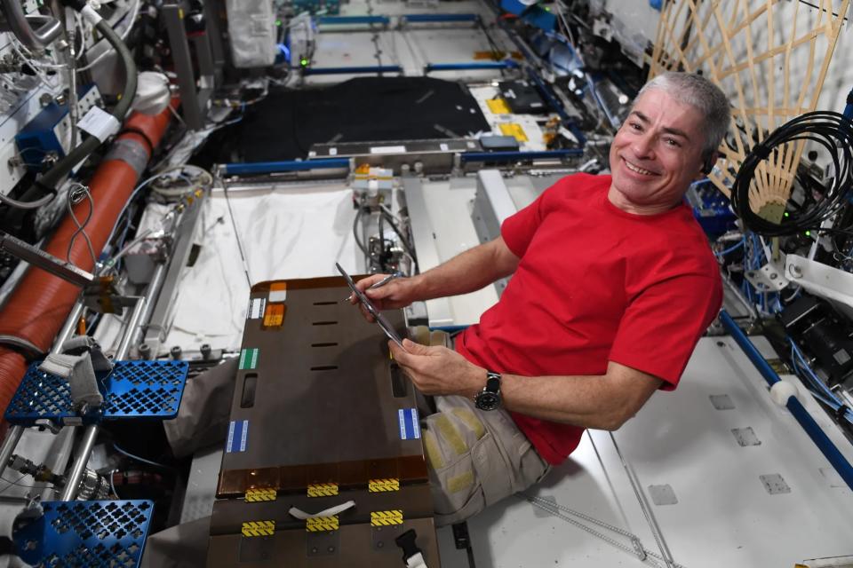 astronaut mark vande hei on the ground of an iss module under a plastic piece