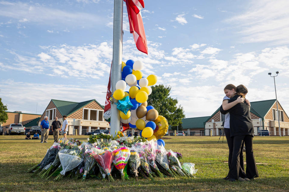 Students embrace near a makeshift memorial. (Jessica McGowan / Getty Images)