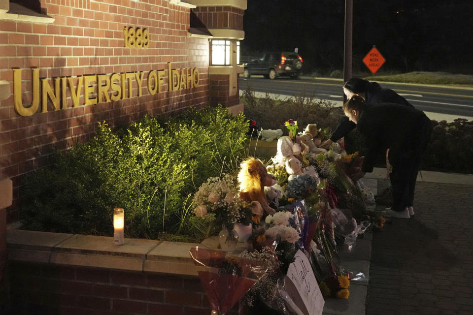 People place flowers at a memorial in front of a campus entrance sign for the University of Idaho (Ted S. Warren / AP file)