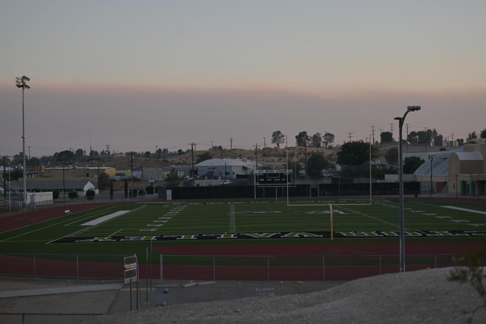 A plume of smoke from a pair of wildfires in mountains can be seen off in the distance in this photo taken outside of Victor Valley High School’s Ray Moore Stadium on Wednesday, Sept. 11, 2024.