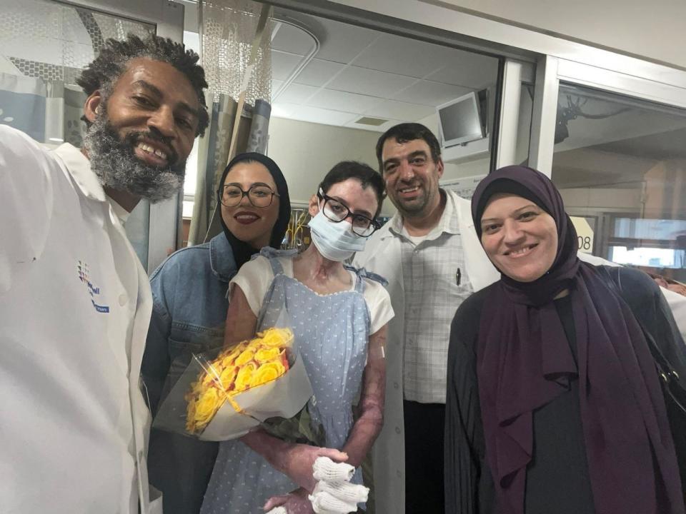 PHOTO: Sara (center) with her sister (second from left), mother (far right) and doctors from Staten Island University Hospital Burn Center during her discharge in May 2024. (HEAL Palestine)