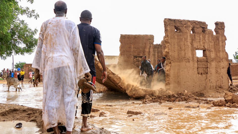 Men bring down the mudbrick wall of a house to act as a make-shift levee amidst flooding in the area of Messawi near Meroe in Sudan's Northern State on August 27, 2024. - AFP/Getty Images