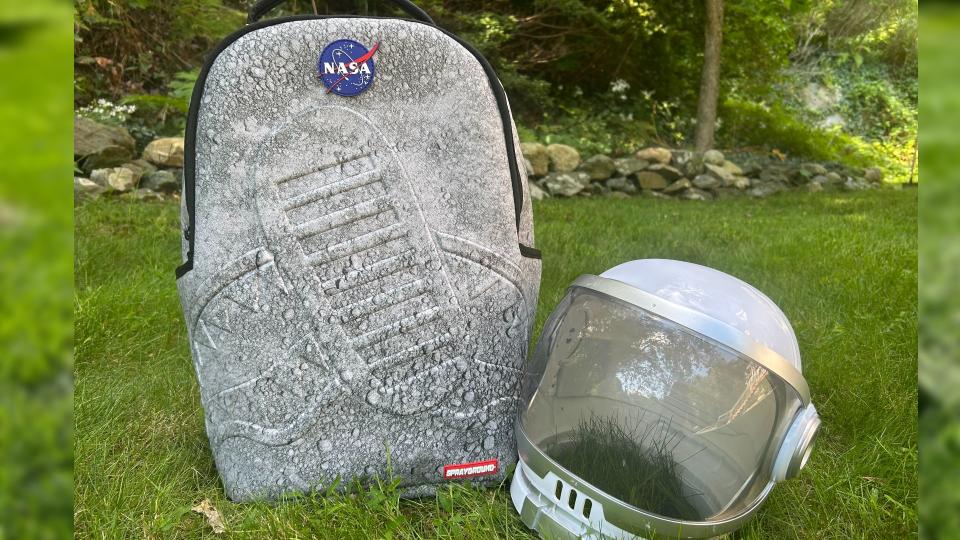 a backpack featuring a mottled grey look similar to the surface of the moon