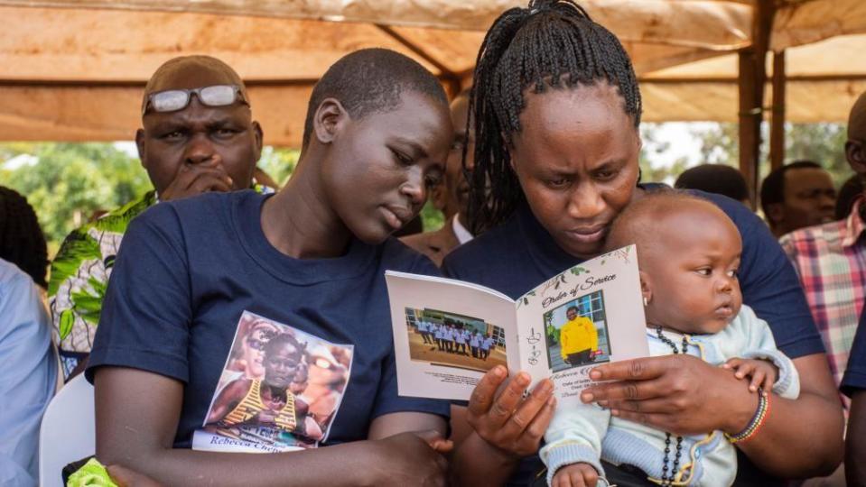 Mourners read the order of service during the funeral of late Ugandan Olympic athlete Rebecca Cheptegei, a sergeant in the Uganda Peoples' Defence Forces, in Bukwo District, some 370km east of Kampala, Uganda, 14 September 2024