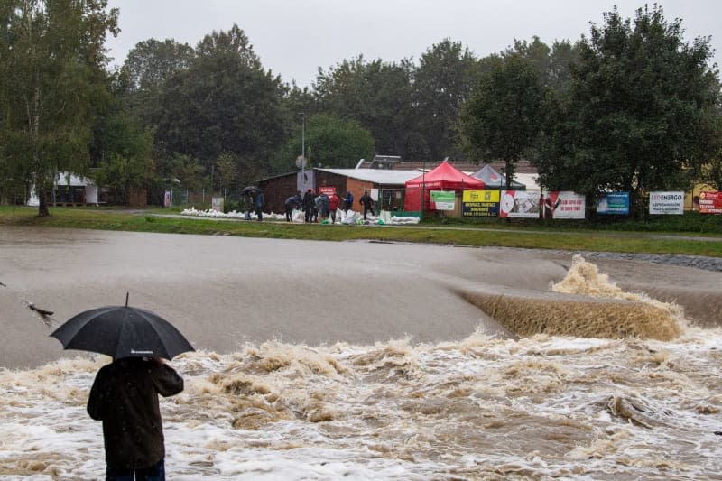 A person with an umbrella looks at the Male River. Heavy continuous rain has led to flood alerts on many rivers and streams in the Czech Republic. Pancer Václav/CTK/dpa