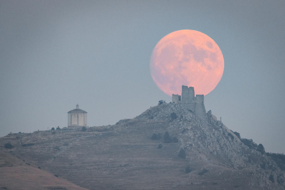 Full harvest moon rising behind Rocca Calascio 