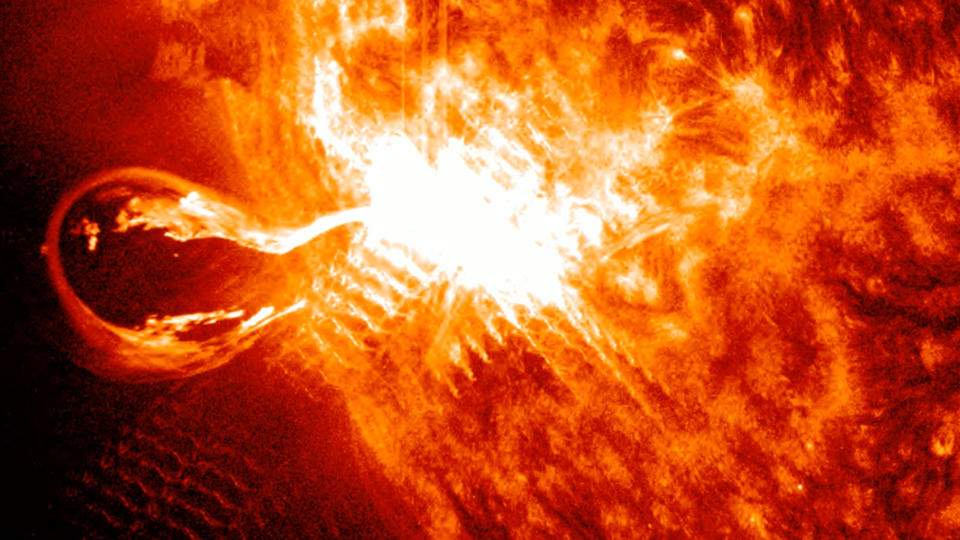 a close up view of the turbulent sun shows a large bright eruption with a huge filament.