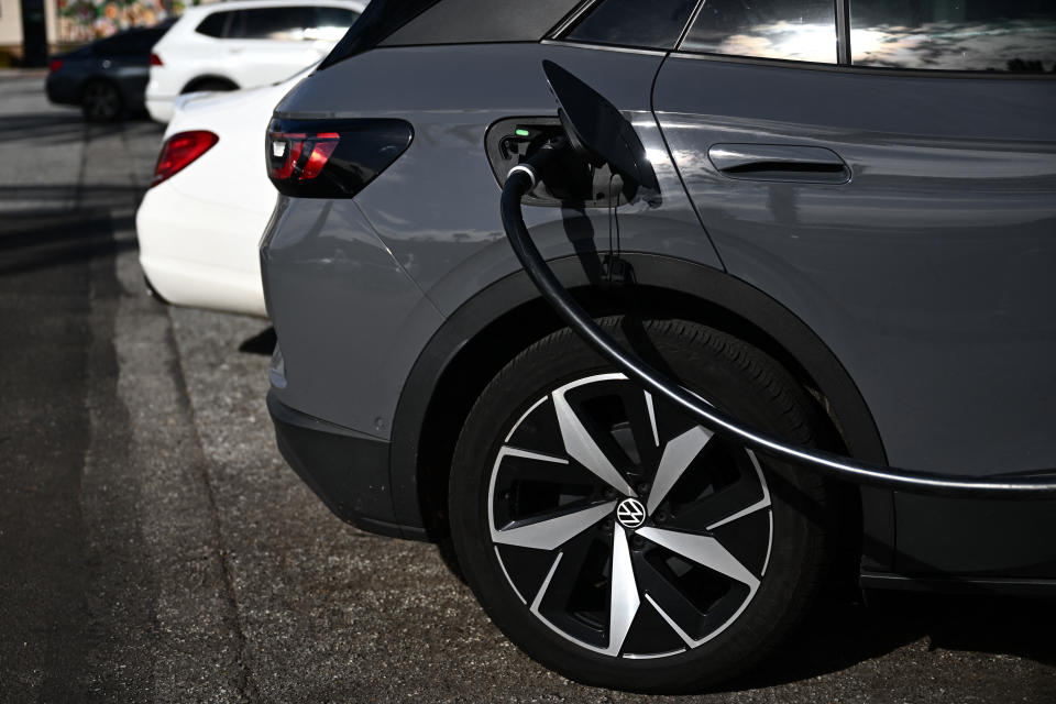 A Volkswagen ID.4 electric vehicle (EV) charges via a CCS DC fast charger from Electrify America at a shopping mall parking lot in Torrance, California, on February 23, 2024. (Photo by Patrick T. Fallon / AFP) (Photo by PATRICK T. FALLON/AFP via Getty Images)