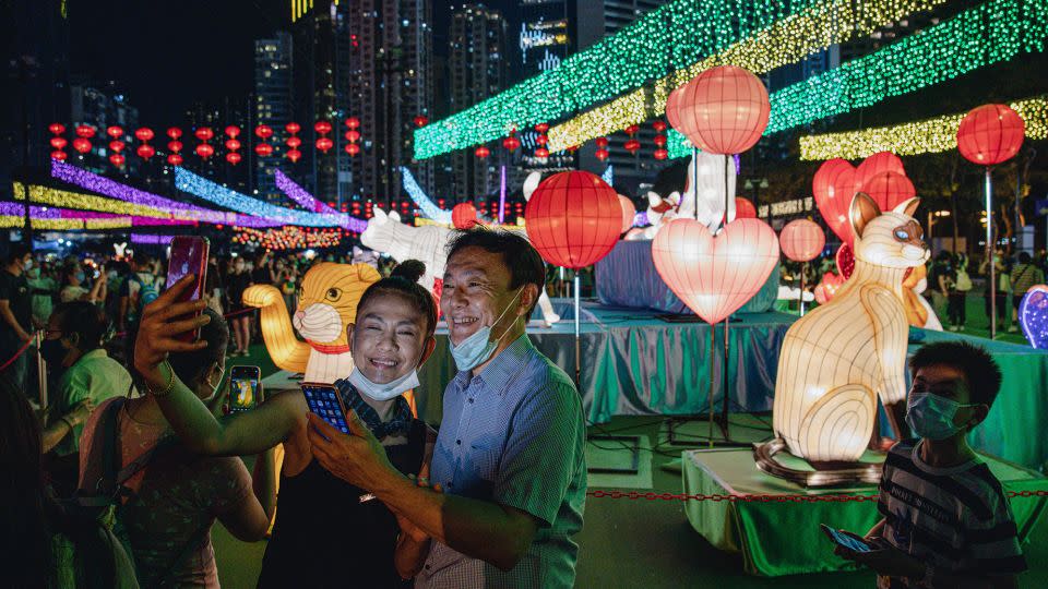 Visitors take selfies in front of light installations at Victoria Park in Hong Kong during the Mid-Autumn Festival in September 2022. - Ryan K. W. Lai/Shutterstock