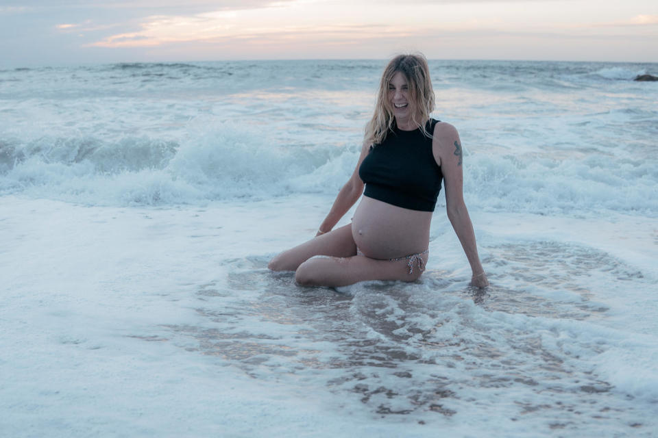 Jennifer Nosek, pregnant, smiles in the ocean, in Mexico. (Laurita Polvorilla)