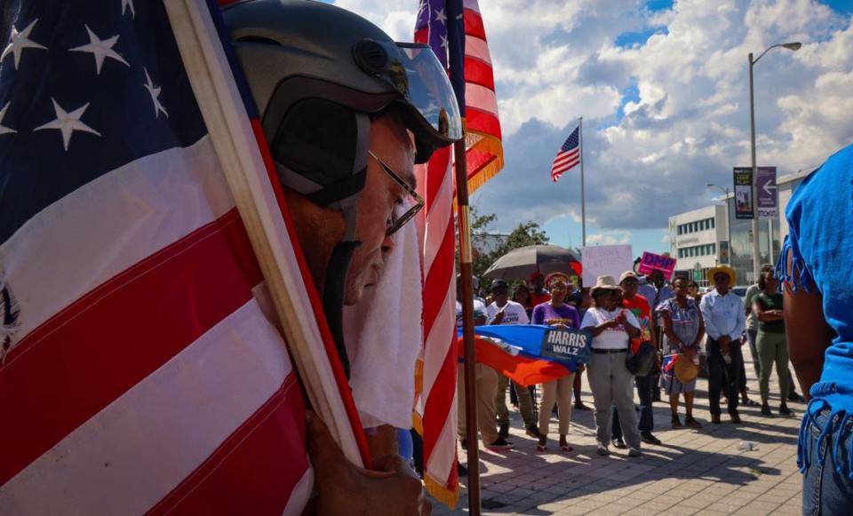 North Miami resident Frandzy Bruce Bernadin, left, wipes the sweat of his brow as he stand in solidarity with members of South Florida’s Haitian community as Miami-Dade Democratic Haitian Caucus hosted a rally against the rhetoric of former President Donald Trump and running mate J.D. Vance, the importance of registration to vote, and participation in the election this November 5th on Sunday, September 22, 2024, in North Miami, Florida.