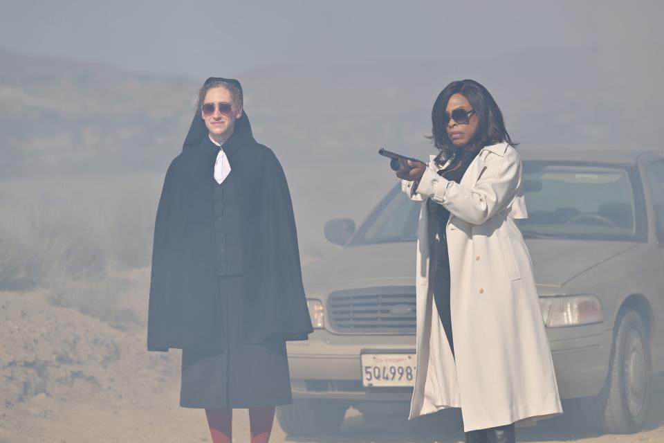 Nun Micaela Diamond, left, and Niecy Nash-Betts, holding a rifle.