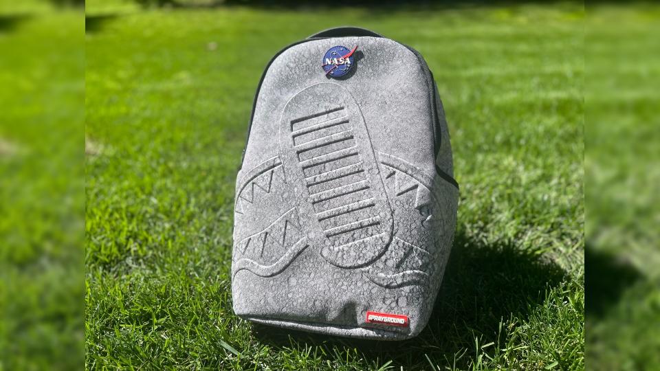  A backpack featuring a mottled grey look similar to the surface of the moon. 