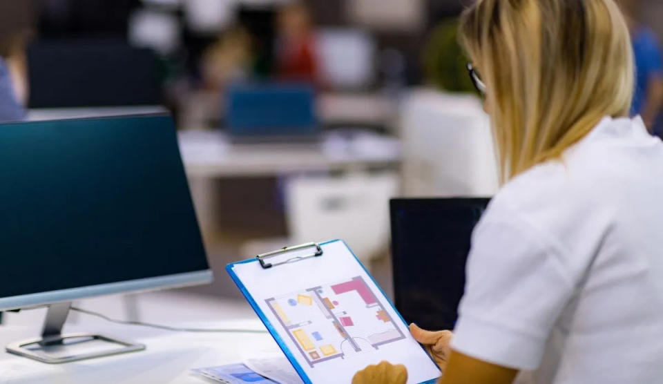 property appraiser sitting at desk reviewing floorplan layout