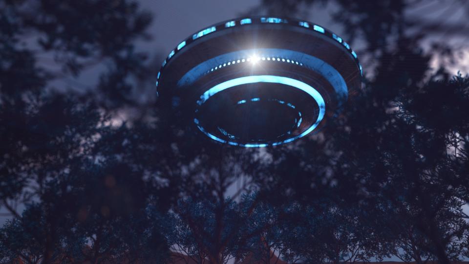  A flying saucer ringed by lights is barely visible through dense trees. 