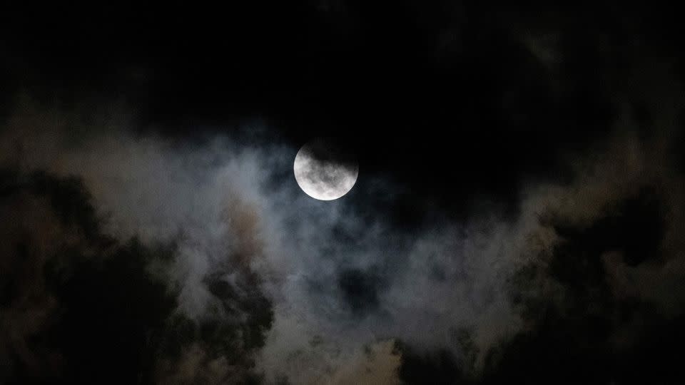 The moon is seen through the clouds during a partial lunar eclipse over Caracas, Venezuela, early on November 8, 2022. - Federico Parra/AFP/Getty Images