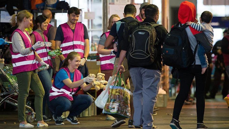 Germans welcome refugees at a train station in 2015