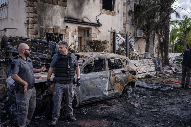 Security forces investigate a damaged vehicle in Kiryat Bialik following a reported strike by the pro-Iranian Hezbollah movement. Ilia Yefimovich/dpa