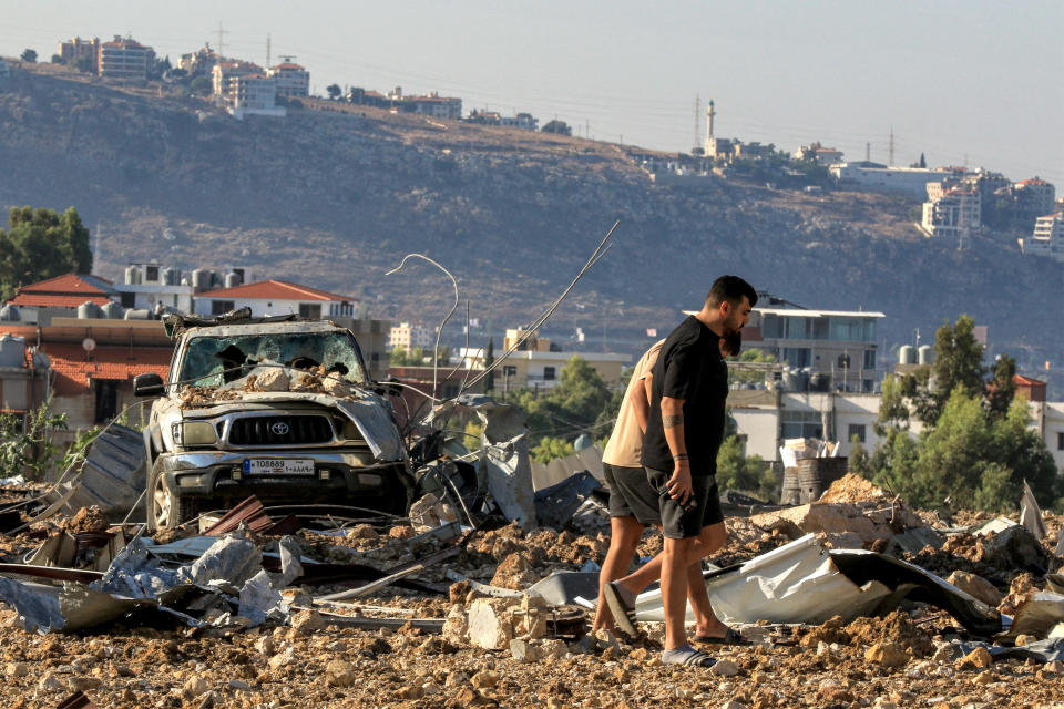 People inspect the site of an Israeli airstrike in Jiyeh, along the highway linking Beirut to the southern city of Sidon in southern Lebanon, Sept. 25, 2024. / Credit: MAHMOUD ZAYYAT/AFP/Getty