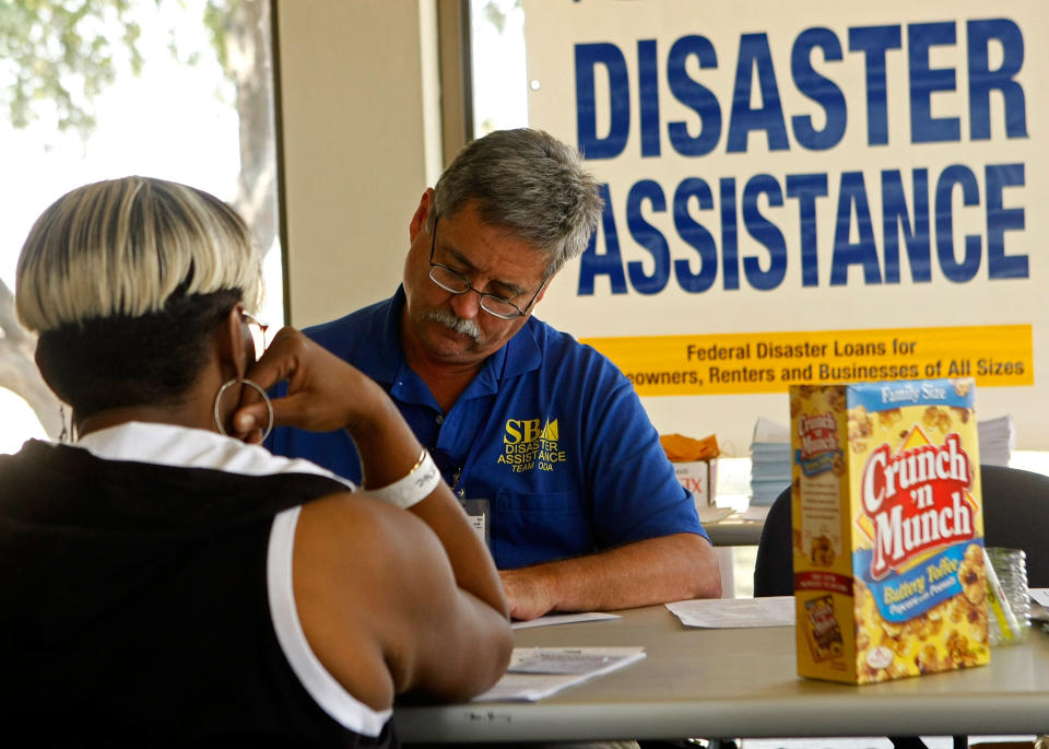 SAN ANTONIO, TX- SEPTEMBER 20: Prescott Lieberg (R) assists an evacuee at a FEMA processing center near a shelter where people from the Houston area were brought to earlier in the week September 20, 2008 in San Antonio, Texas. Many people are still without power and some do not have a livable home to go back to. Hurricane Ike caused wide spread damage and power outages through out the Texas coast and is responsible for several deaths.  (Photo by Mark Wilson/Getty Images)