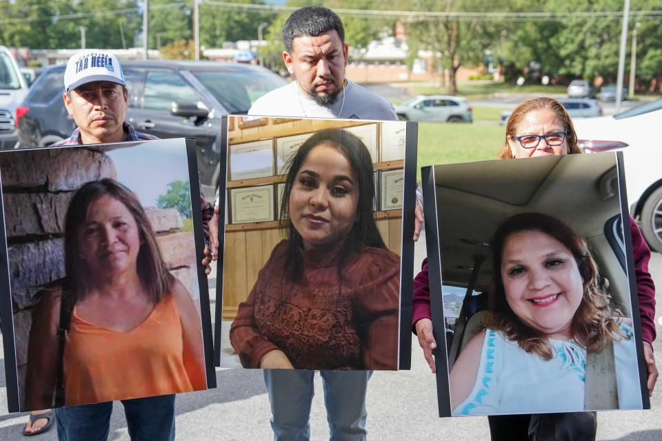 Family members of missing factory workers in Erwin, Tenn., hold up images of their loved ones. (Saul Young/News Sentinel/USA Today Network via Imagn Images)