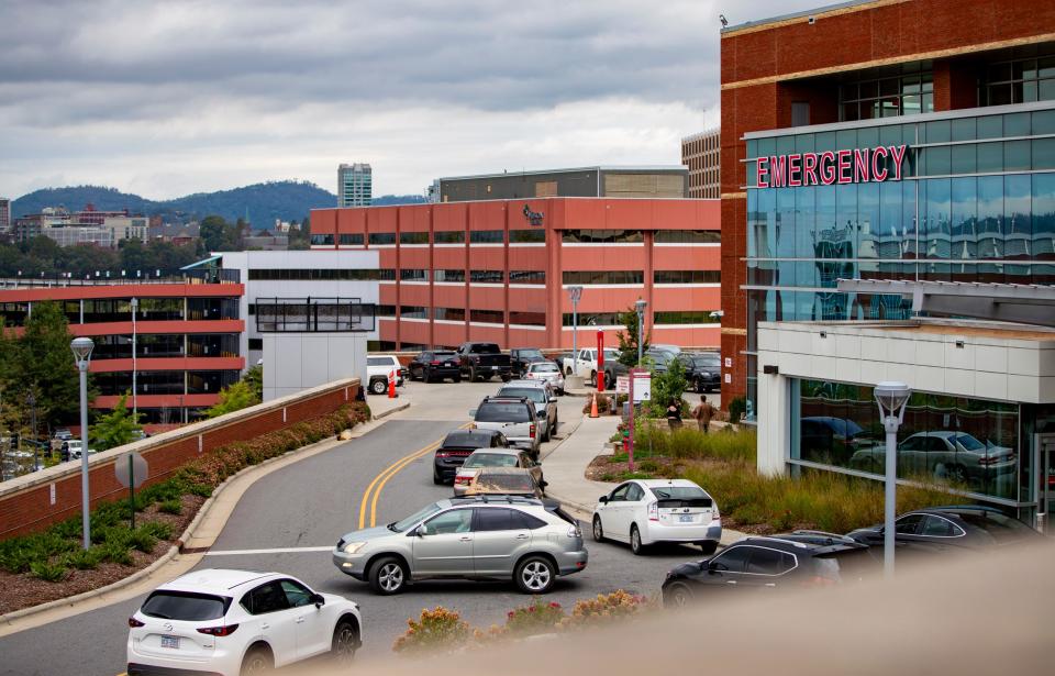 Asheville residents line up outside the emergency room at Mission Health Saturday afternoon in downtown Asheville.