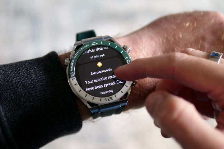 A person wearing the Huawei Watch Ultimate, viewing notifications.