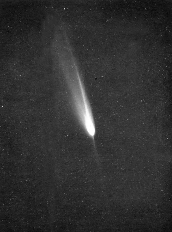 A black and white image, mostly black, witha  white glowing orb in the center, with a tail streaking upward to the left.