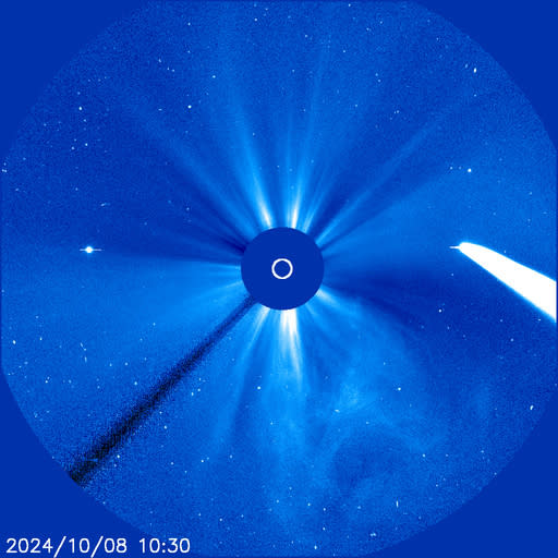 A blue square with circles within. From the center, light jets out into space.