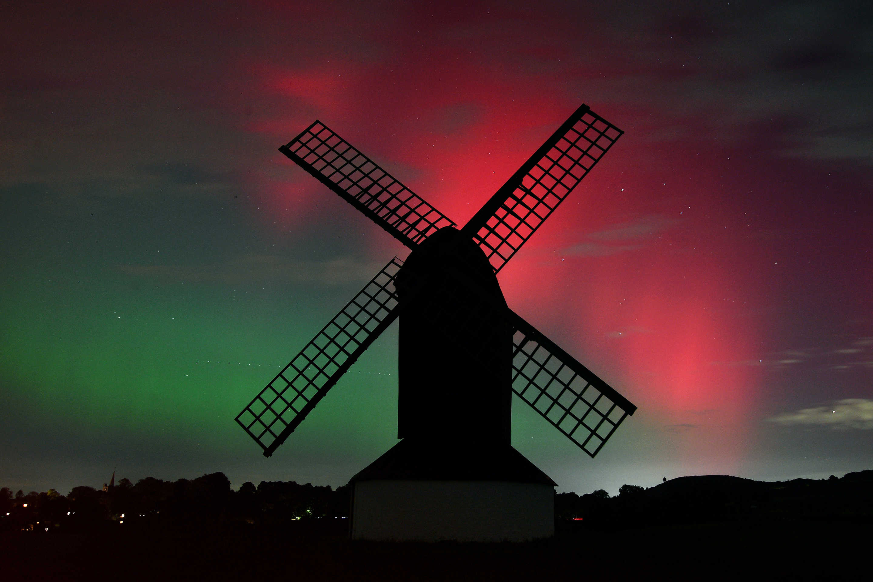 Aurora borealis against silhouette of windmill.