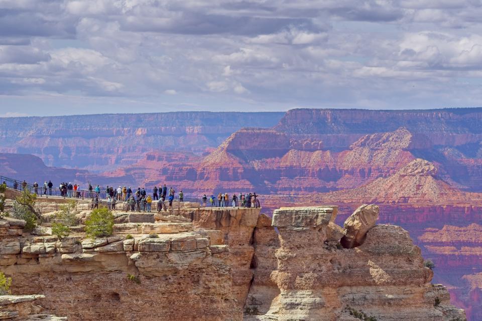 Overcrowded Mather point along the south rim of the Grand Canyon. The long promontory extends out into the canyon with expansive views of the colorful rock formations.