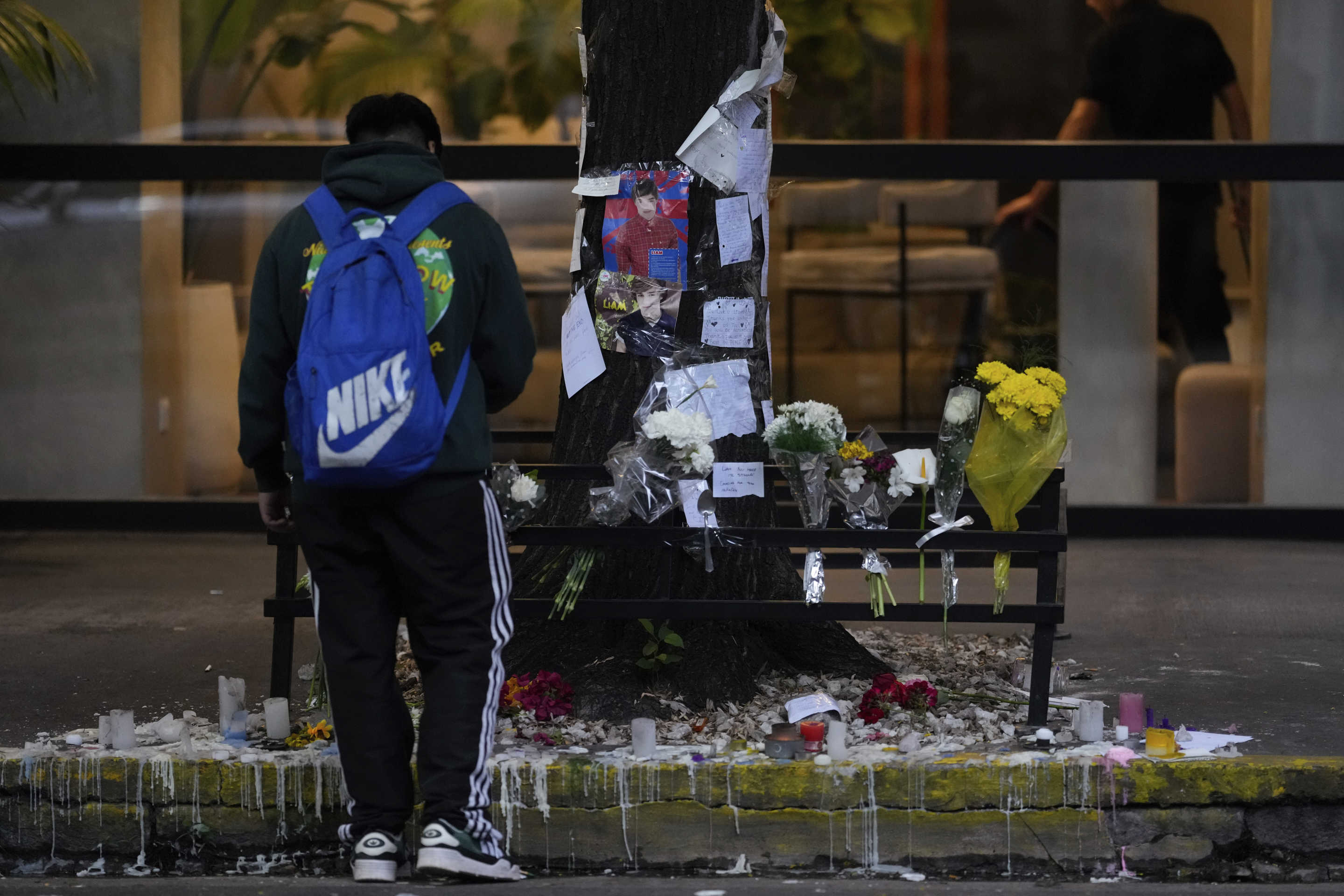 A fan stands in front of a makeshift memorial outside the hotel where former One Direction singer Liam Payne was found dead after falling from a balcony in Buenos Aires, Argentina, the morning after his death, Thursday, Oct. 17, 2024. (Natacha Pisarenko/AP)