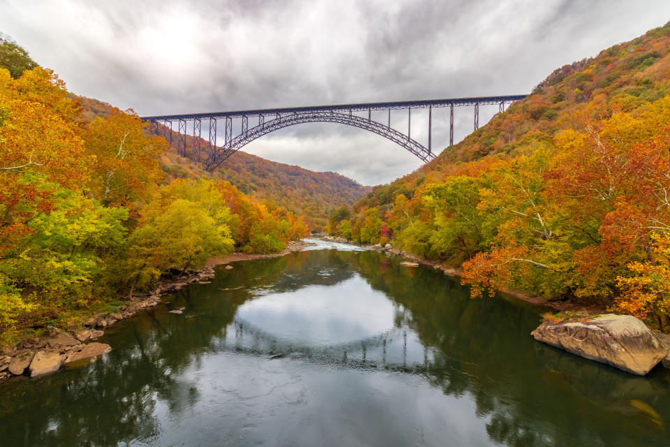 An aerial view of a colorful autumn landscape with a bridge in New River Gorge National Park