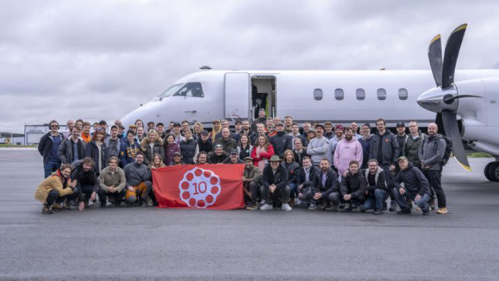 The team at 10 Chambers standing outside of a plane.