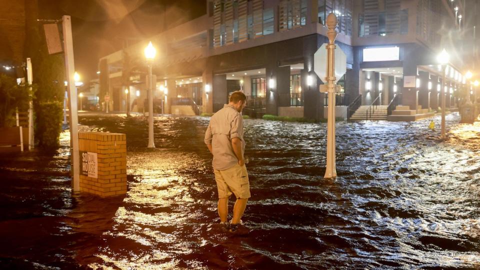 PHOTO: Brandon Marlow walks through surge waters flooding the street after Hurricane Milton came ashore in the Sarasota area on Oct. 9, 2024, in Fort Myers, Fla. (Joe Raedle/Getty Images)