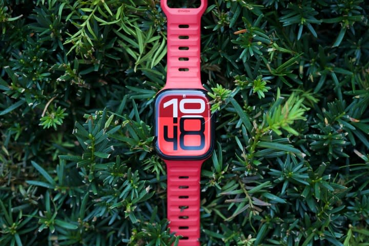 The Apple Watch Series 10 sitting on top of a green bush.