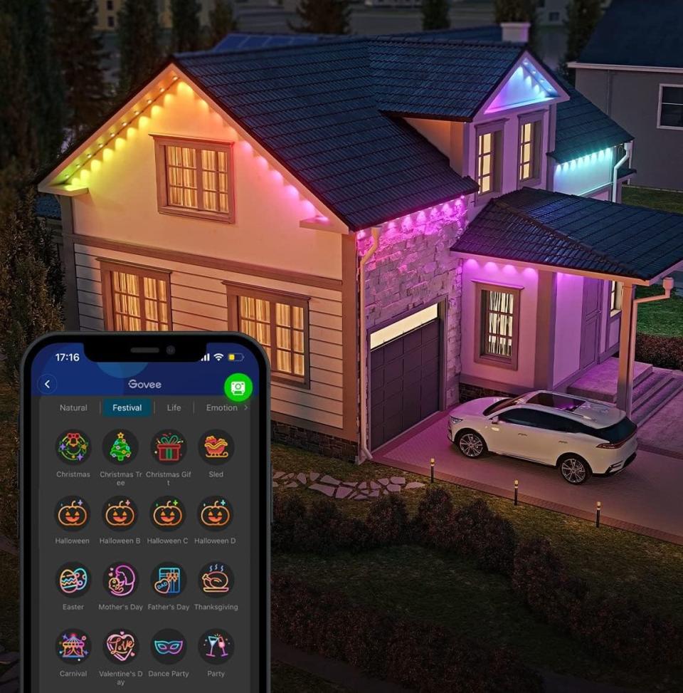 A phone showing the Govee app, alongside a house with the lights installed.