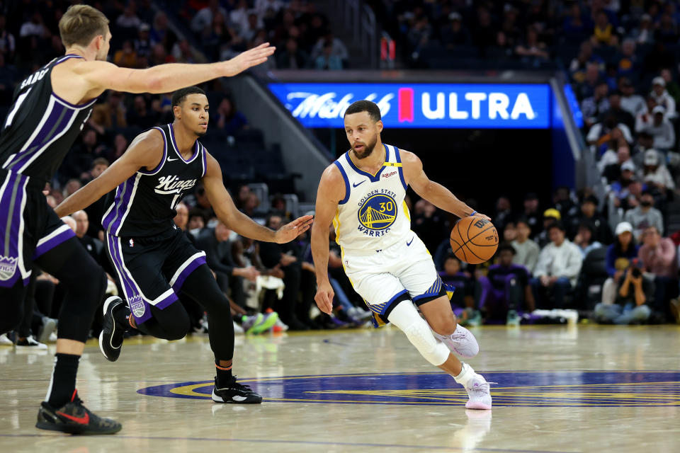 SAN FRANCISCO, CALIFORNIA - OCTOBER 11: Stephen Curry #30 of the Golden State Warriors is guarded by Domantas Sabonis #11 and Keegan Murray #13 of the Sacramento Kings during their preseason game at Chase Center on October 11, 2024 in San Francisco, California. NOTE TO USER: User expressly acknowledges and agrees that, by downloading and/or using this photograph, user is consenting to the terms and conditions of the Getty Images License Agreement.  (Photo by Ezra Shaw/Getty Images)