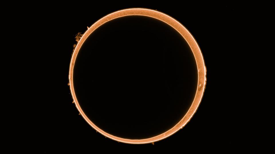  A dark black circle covers most of the sun, leaving just a bright orange ring around its edges. 