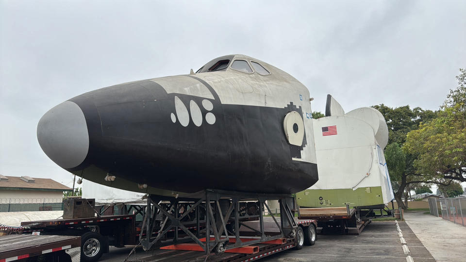  Closeup photo of the black and white nose of a space shuttle mockup . 