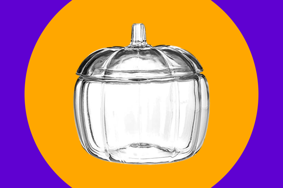 The glass pumpkin candy jar on an orange and purple background