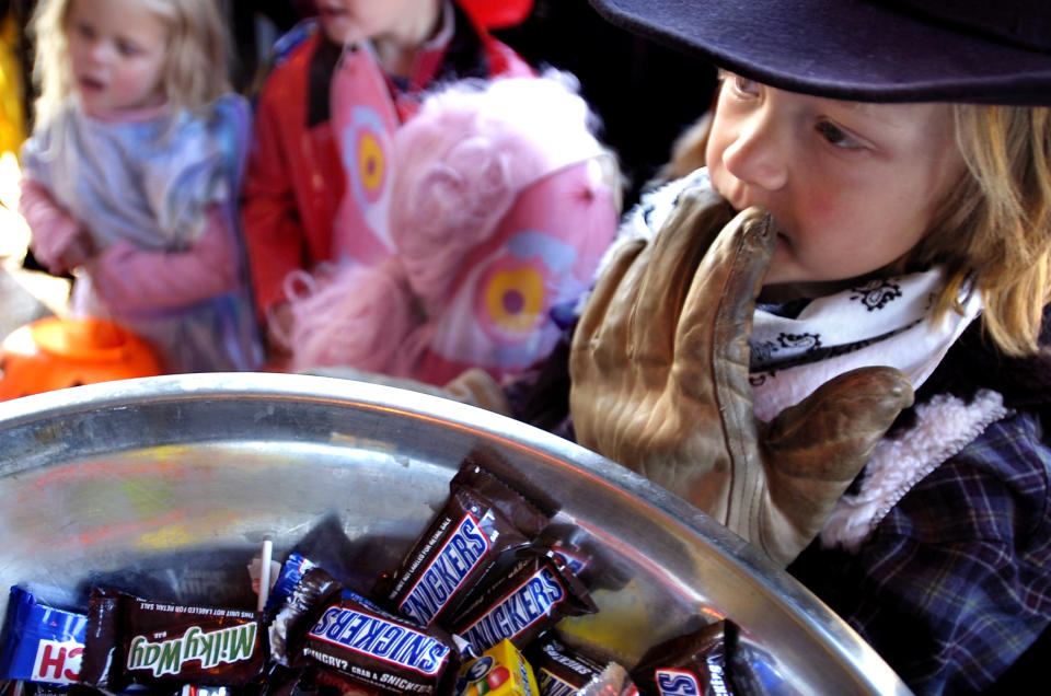 Cowboy Cole Skilbred (CQ), 7, of Boulder, waits to get treats from a candy bowl at Old Chicago's for the Munchkin Masquerade on the Pearl Street Mall for Halloween on Tuesday. (Photo by Josh Lawton/Digital First Media/Boulder Daily Camera via Getty Images)