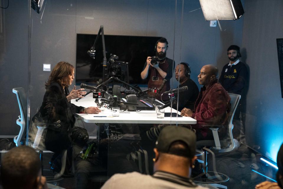 Vice President Kamala Harris in a radio studio with host Charlamagne Tha God  and several staffers.