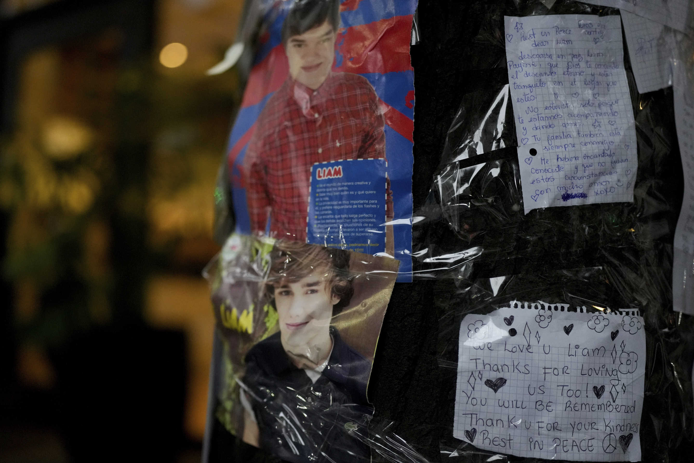 Photos of former One Direction singer Liam Payne and messages from fans are taped to a tree outside the hotel where he was found dead after falling from a balcony in Buenos Aires, Argentina, the morning after the incident, Thursday, Oct. 17, 2024. (Natacha Pisarenko/AP)