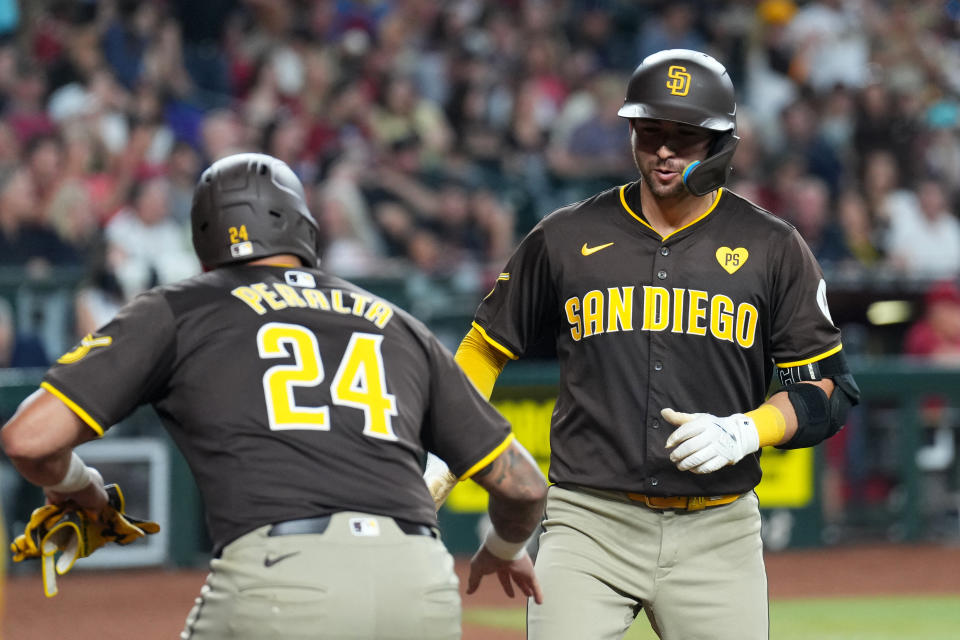 Sep 28, 2024; Phoenix, Arizona, USA; San Diego Padres catcher Kyle Higashioka (20) slaps hands with San Diego Padres outfielder David Peralta (24) after hitting a two run home run against the Arizona Diamondbacks during the ninth inning at Chase Field. Mandatory Credit: Joe Camporeale-Imagn Images