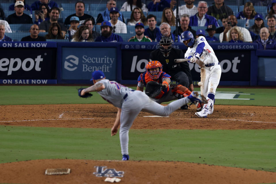 Oct 13, 2024; Los Angeles, California, USA; Los Angeles Dodgers shortstop Mookie Betts (50) hits a three run double against the New York Mets in the ninth inning during game one of the NLCS for the 2024 MLB Playoffs at Dodger Stadium. Mandatory Credit: Jason Parkhurst-Imagn Images